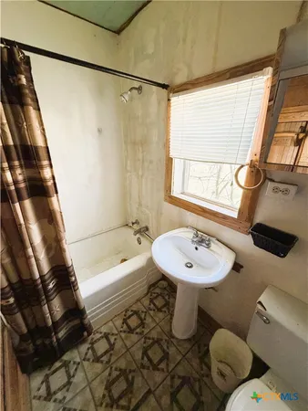 a bathroom with a sink toilet a mirror and bathtub
