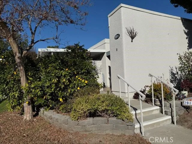 a view of a house with a small yard and potted plants