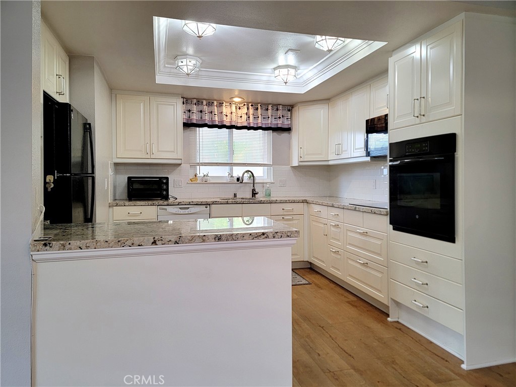 2082 Ronda Granada, Unit D Laguna Woods, CA 92637 - Photo 21 of 36 a kitchen with stainless steel appliances granite countertop a sink a stove and cabinets
