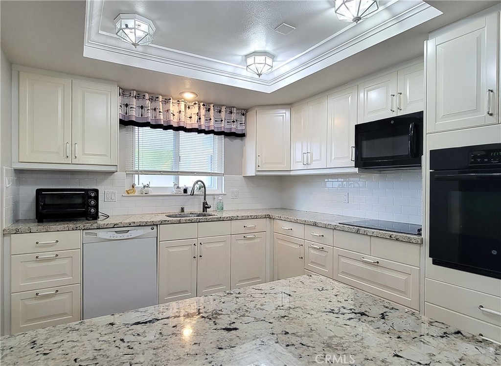 2082 Ronda Granada, Unit D Laguna Woods, CA 92637 - Photo 22 of 36 a kitchen with stainless steel appliances granite countertop a stove a sink and a microwave