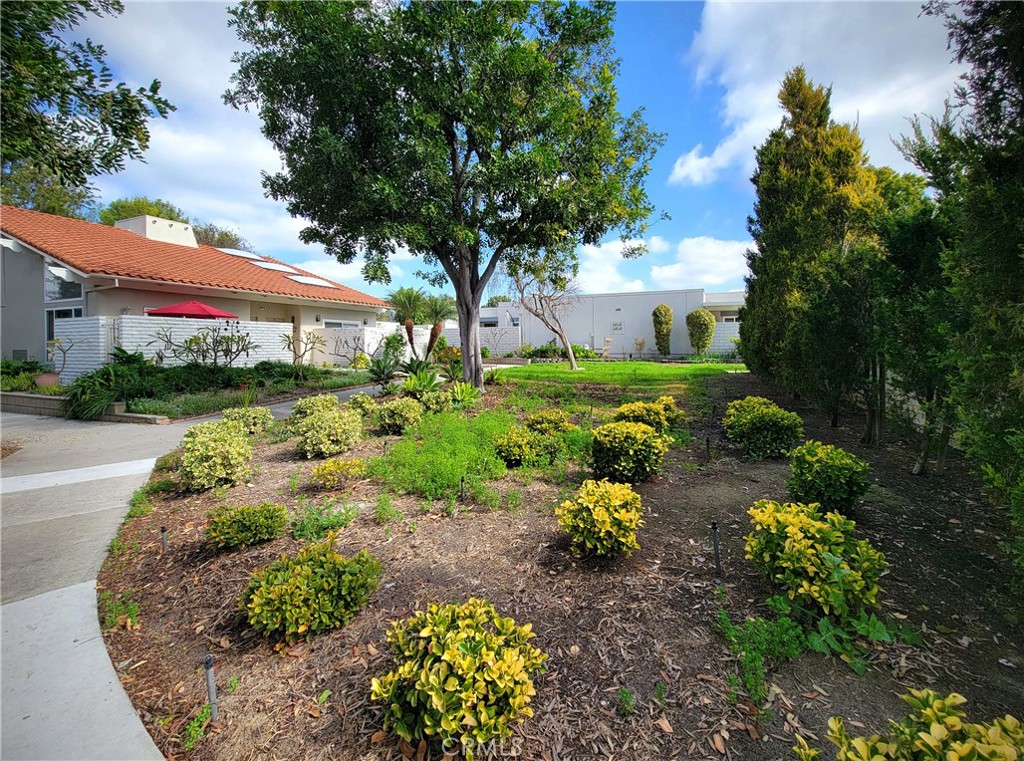 2082 Ronda Granada, Unit D Laguna Woods, CA 92637 - Photo 34 of 36 a front view of a house with a yard and outdoor seating
