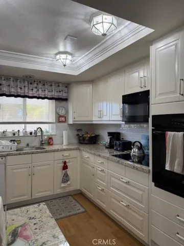 a kitchen with granite countertop a sink and cabinets