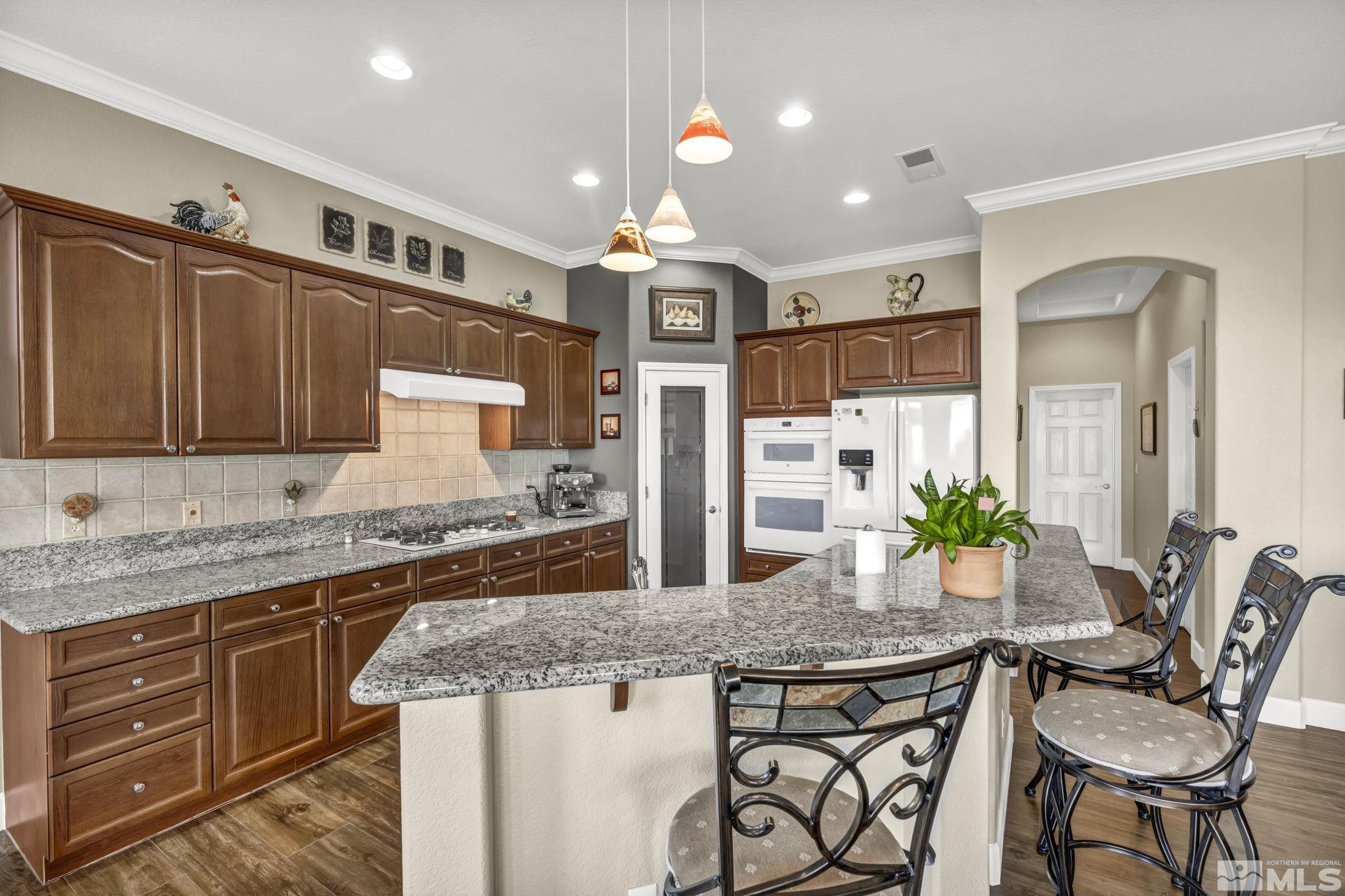 6824 Marble Canyon Road Reno, NV 89511 - Photo 14 of 30 a kitchen with stainless steel appliances granite countertop stove top oven and refrigerator