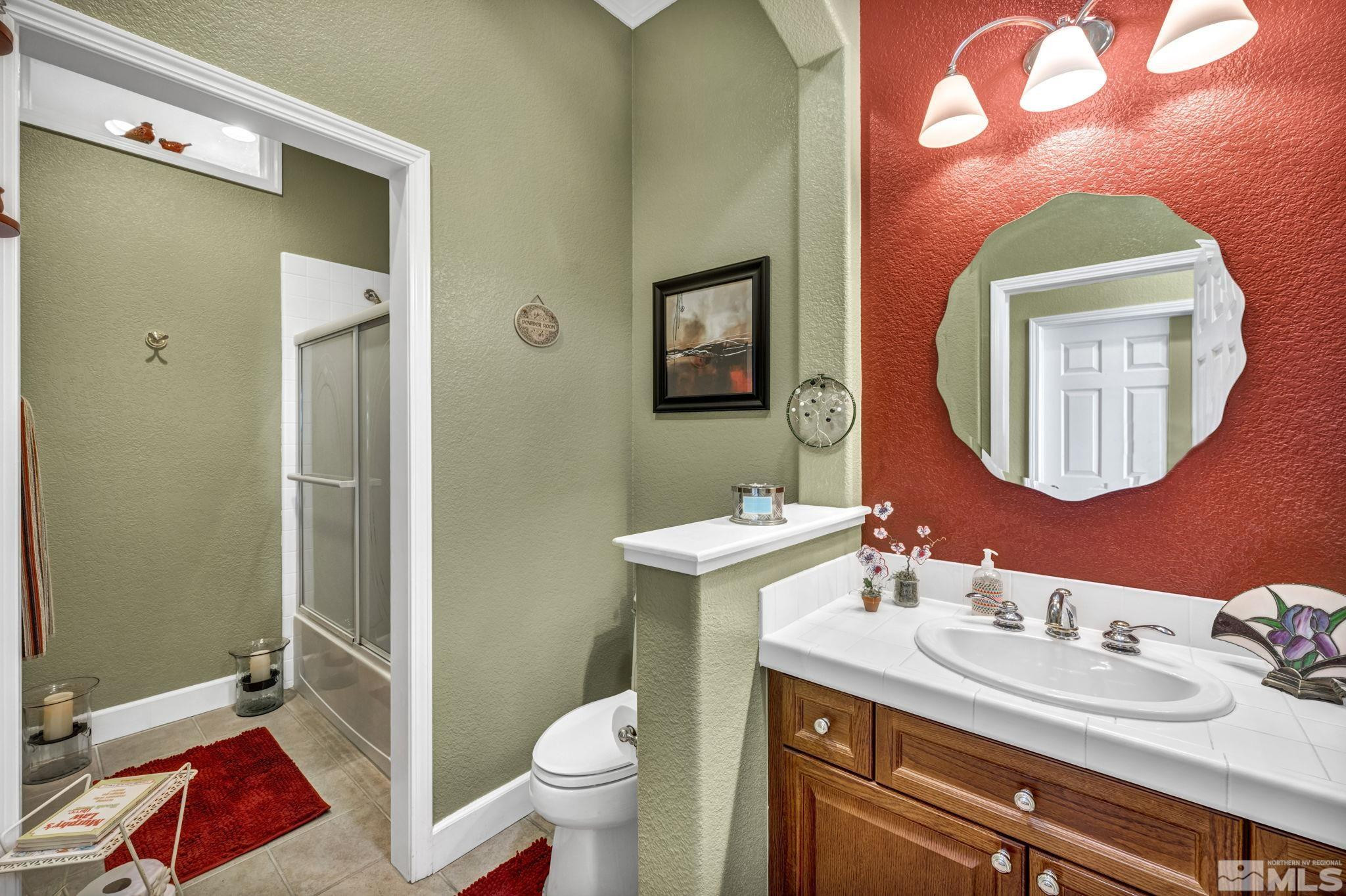 6824 Marble Canyon Road Reno, NV 89511 - Photo 17 of 30 a bathroom with a granite countertop toilet a sink and a mirror
