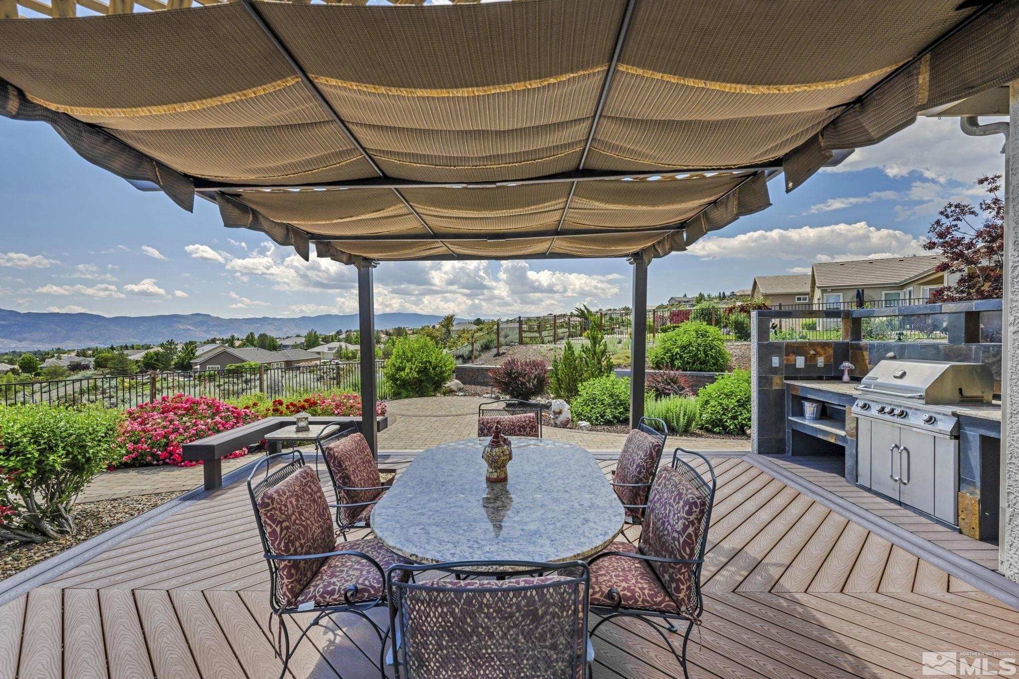 6824 Marble Canyon Road Reno, NV 89511 - Photo 2 of 30 a view of a patio with a dining table and chairs under an umbrella