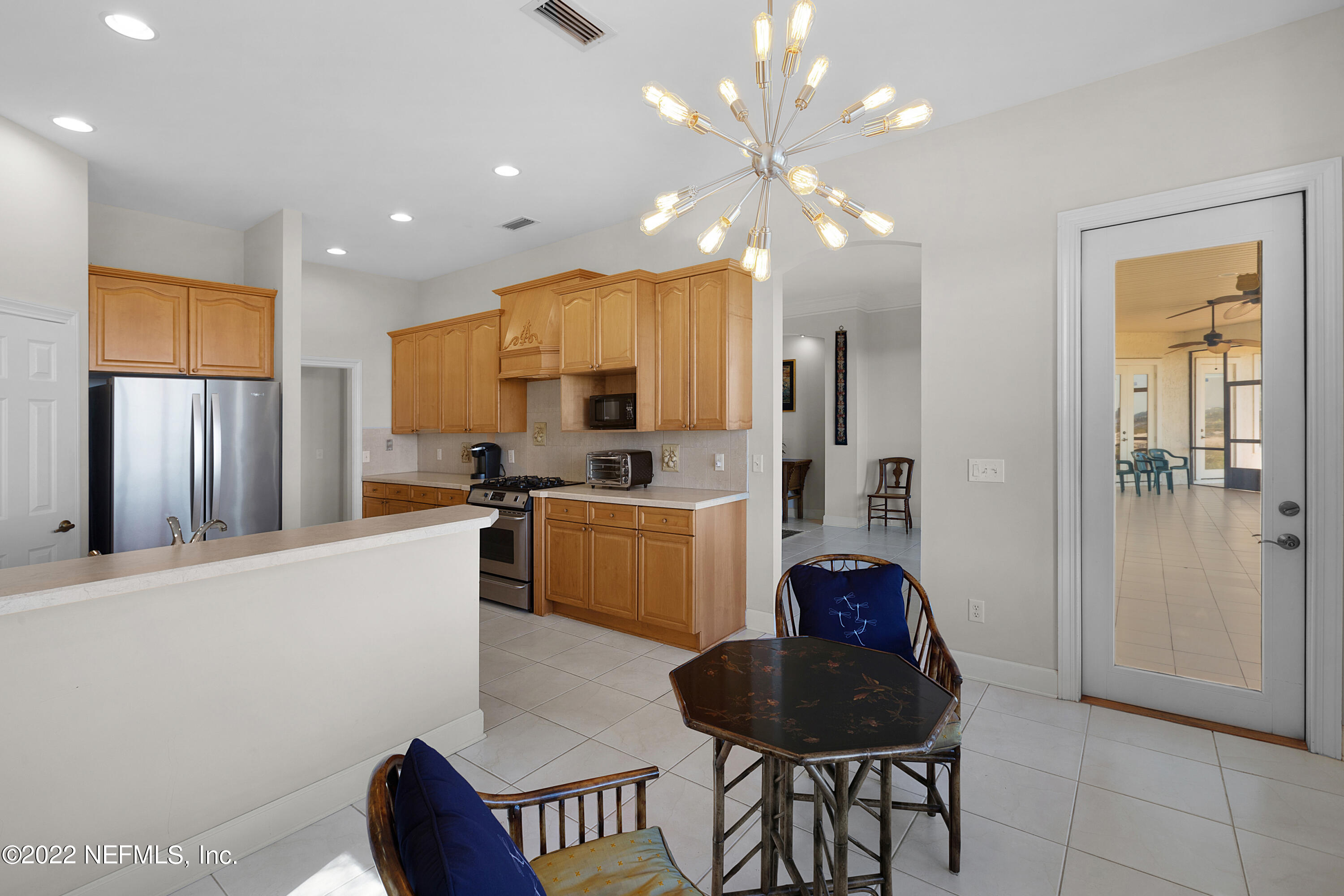 13263 Fort Caroline Road Jacksonville, FL 32225 - Photo 20 of 64 a kitchen with stainless steel appliances granite countertop a refrigerator a sink dishwasher a stove and a dining table with wooden floor
