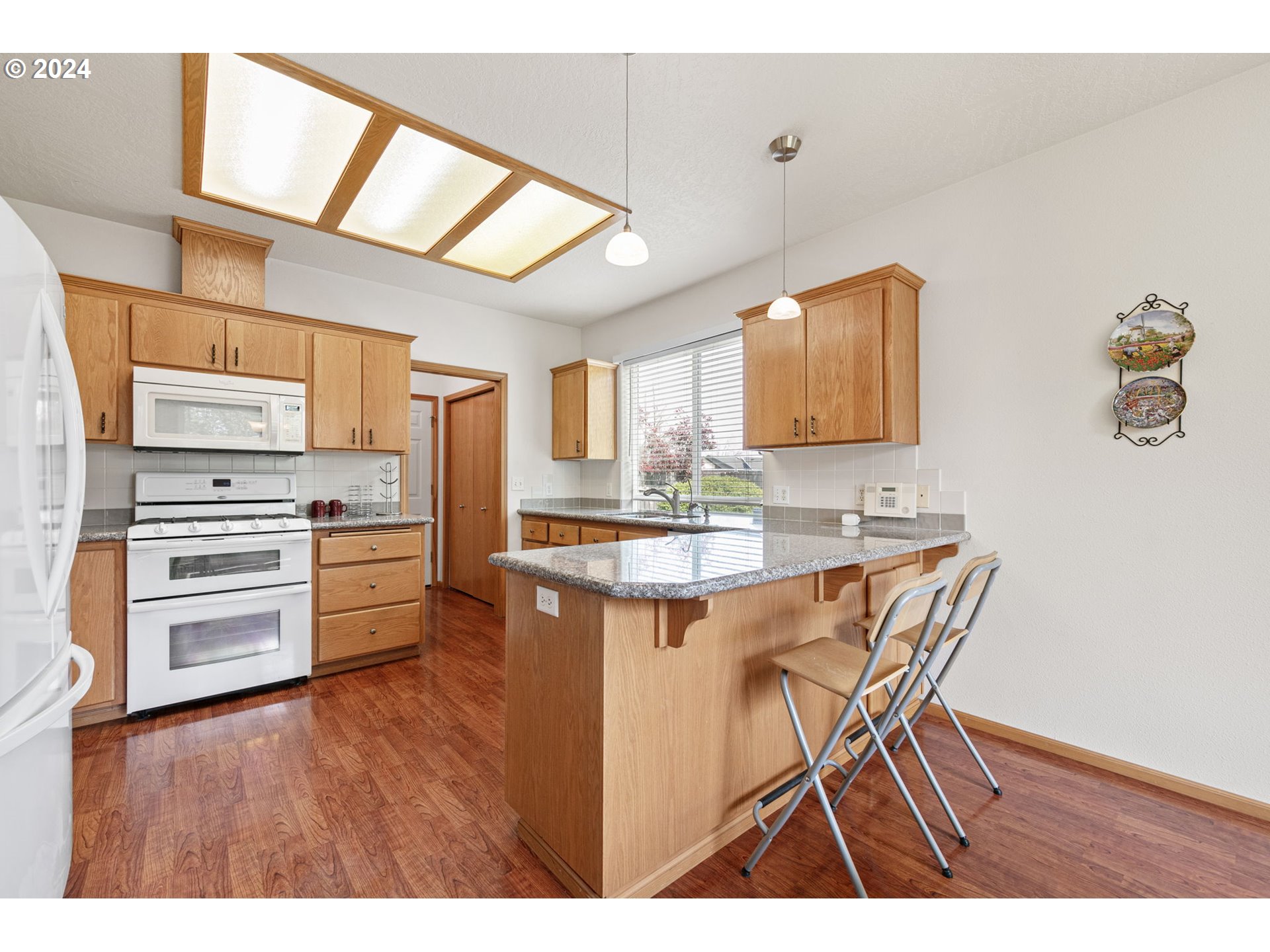 815 R Street Springfield, OR 97477 - Photo 18 of 37 a kitchen with stainless steel appliances kitchen island granite countertop a sink cabinets and wooden floor