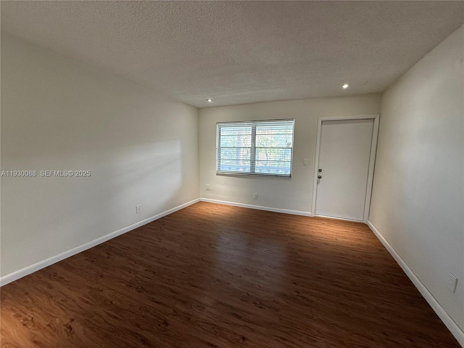 900 Tallwood Avenue, Unit 306 Hollywood, FL 33021 - Photo 12 of 30 an empty room with wooden floor and windows