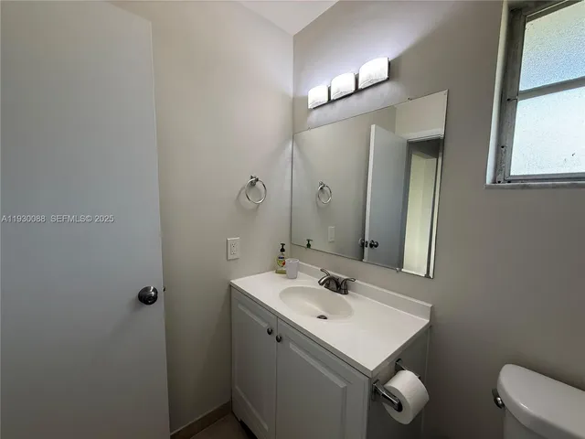 a bathroom with a sink toilet and mirror