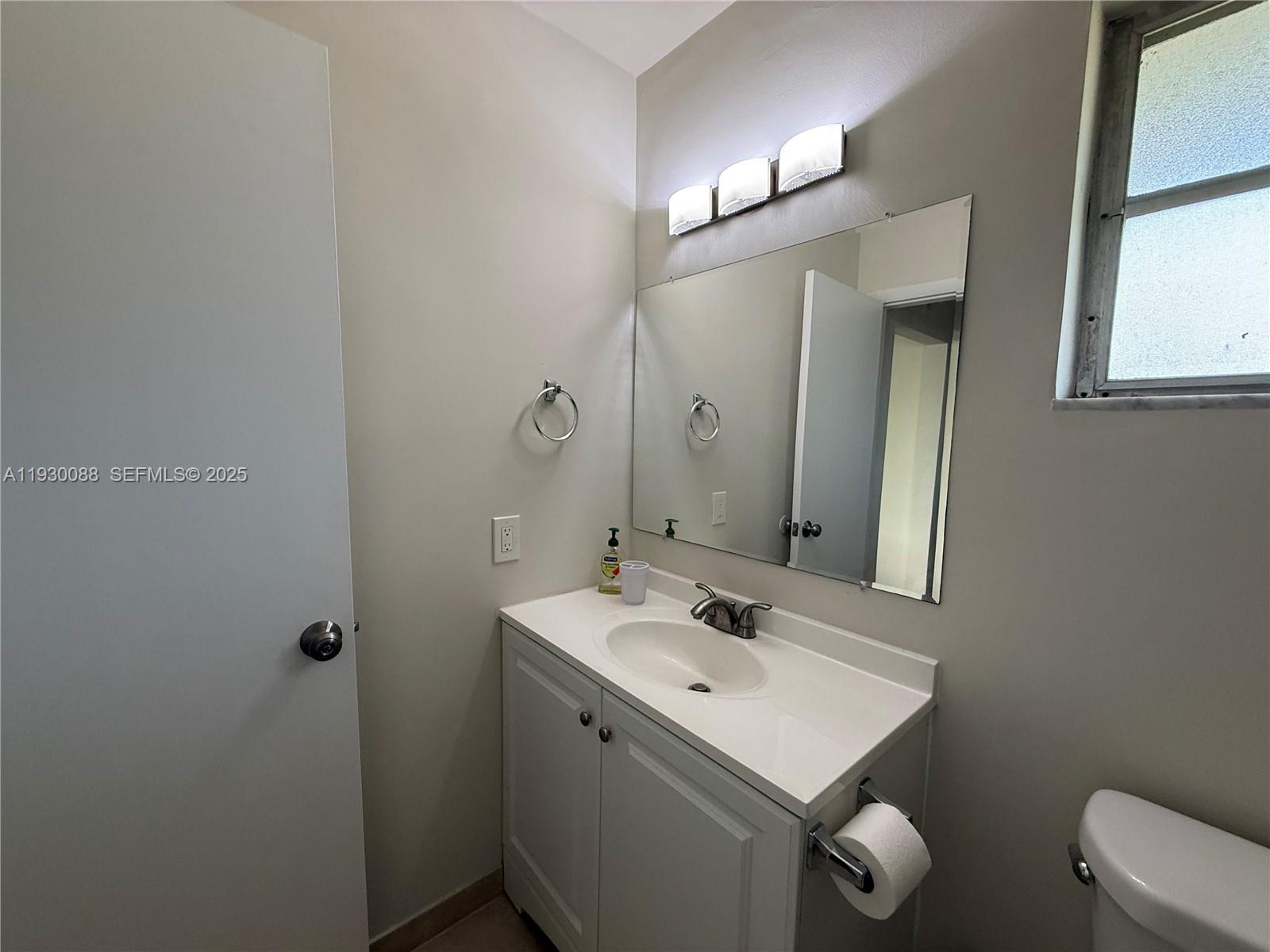900 Tallwood Avenue, Unit 306 Hollywood, FL 33021 - Photo 14 of 30 a bathroom with a sink toilet and mirror