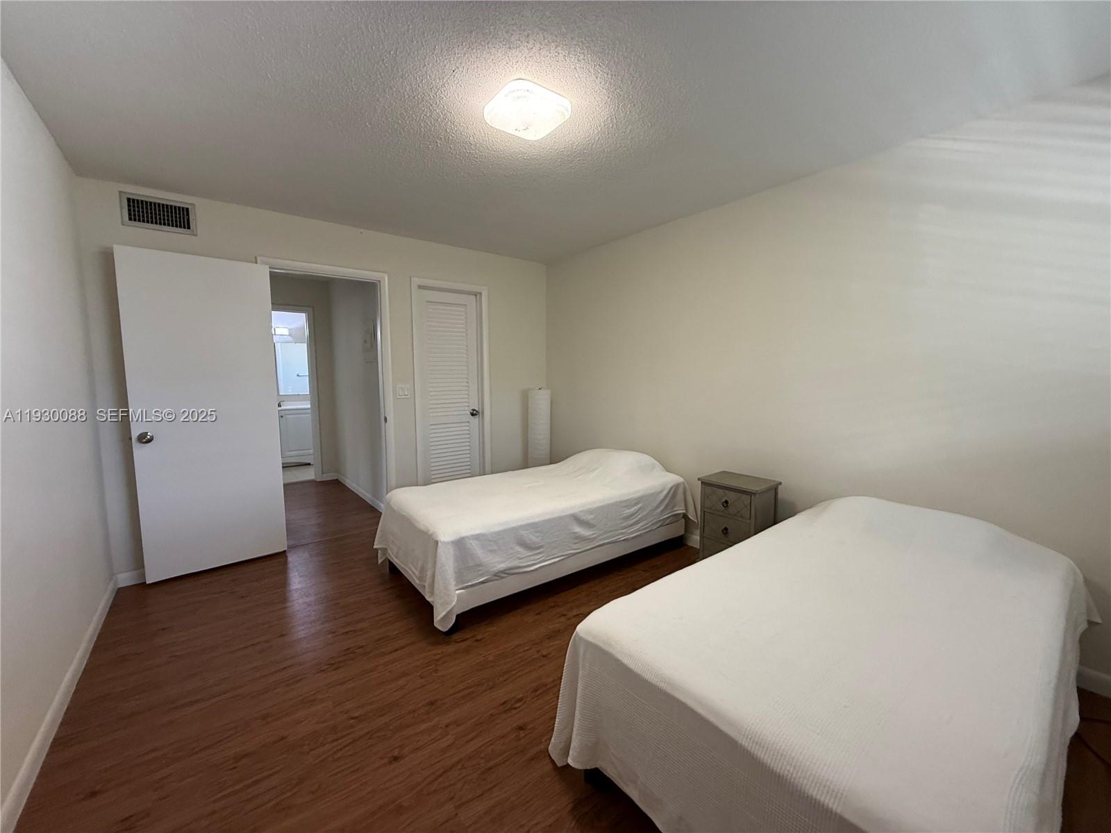 900 Tallwood Avenue, Unit 306 Hollywood, FL 33021 - Photo 17 of 30 a bedroom with two beds and wooden floor