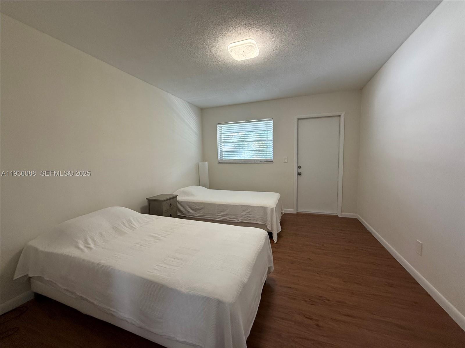 900 Tallwood Avenue, Unit 306 Hollywood, FL 33021 - Photo 18 of 30 a bedroom with a bed and wooden floor