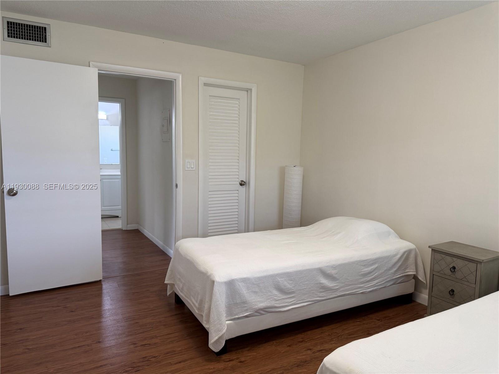 900 Tallwood Avenue, Unit 306 Hollywood, FL 33021 - Photo 19 of 30 a bedroom with a bed and wooden floor