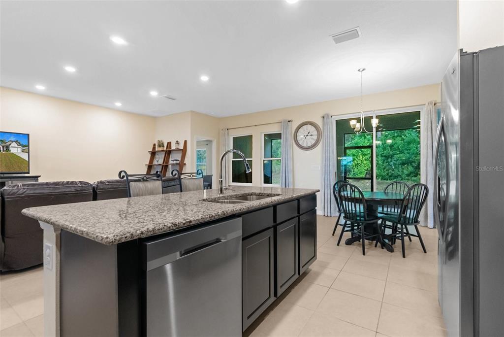6283 Grapewood Road Spring Hill, FL 34609 - Photo 19 of 41 a dining hall with stainless steel appliances granite countertop a kitchen island a stove and a sink