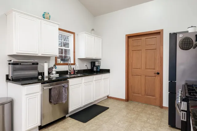 a kitchen with granite countertop white cabinets and sink