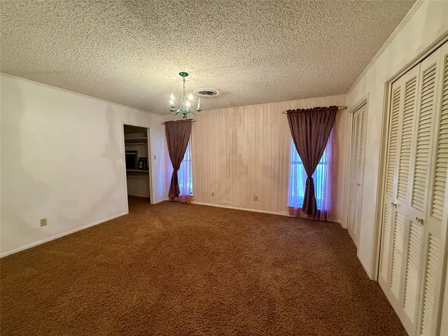 an empty room with a ceiling fan and a window