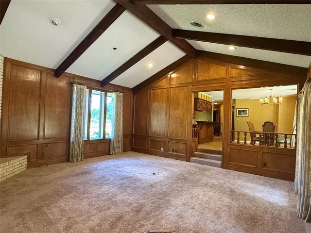 a view of an empty room with glass door and chair