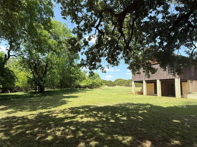 a front view of a house with a garden and trees
