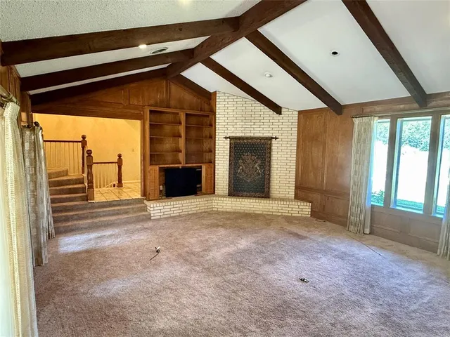 a view of empty room with a fireplace and windows