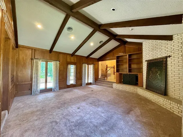 a view of an empty room with a fireplace and a window