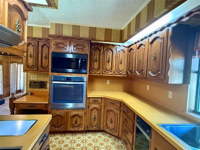 a kitchen with stainless steel appliances granite countertop a sink a stove and cabinets