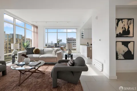 a living room with furniture potted plant and a large window
