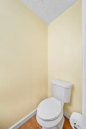 a white toilet sitting next to a white wall
