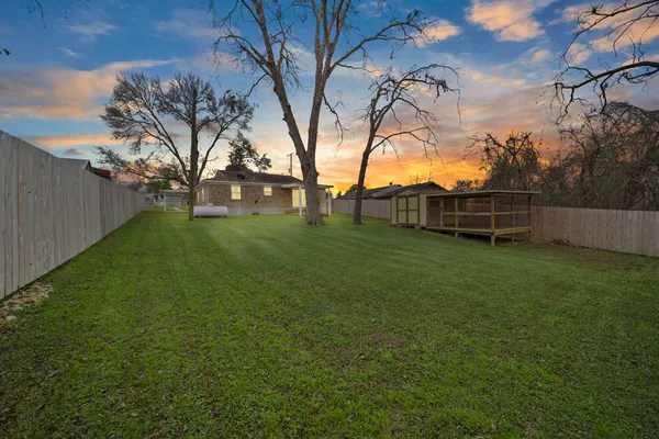 a view of a backyard with wooden fence