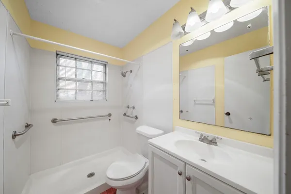 a bathroom with a sink a toilet and shower