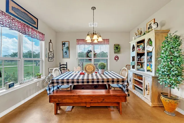 a living room with furniture a chandelier and a bookshelf