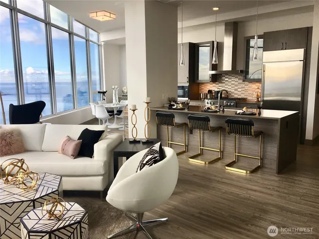 a living room with furniture wooden floor and large window