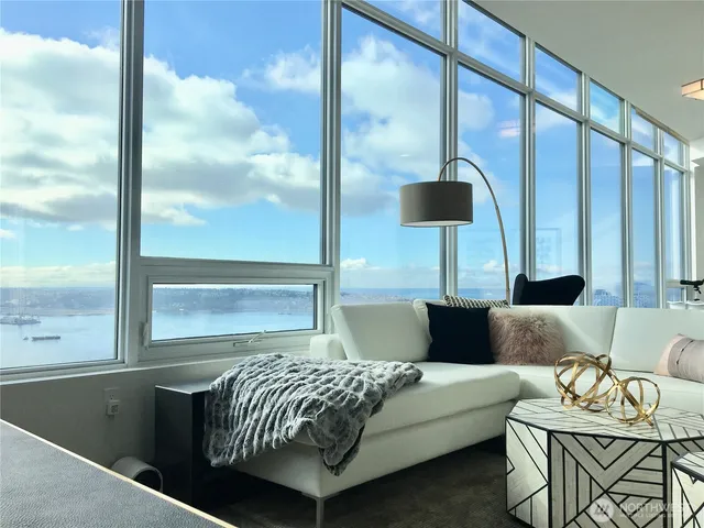 a living room with a bed and glass window