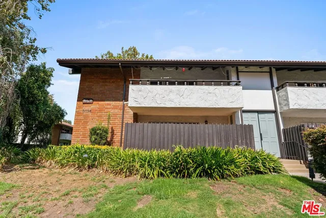 a view of a house with a wooden fence