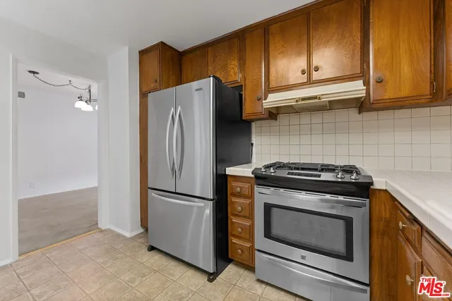a kitchen with a refrigerator stove and cabinets
