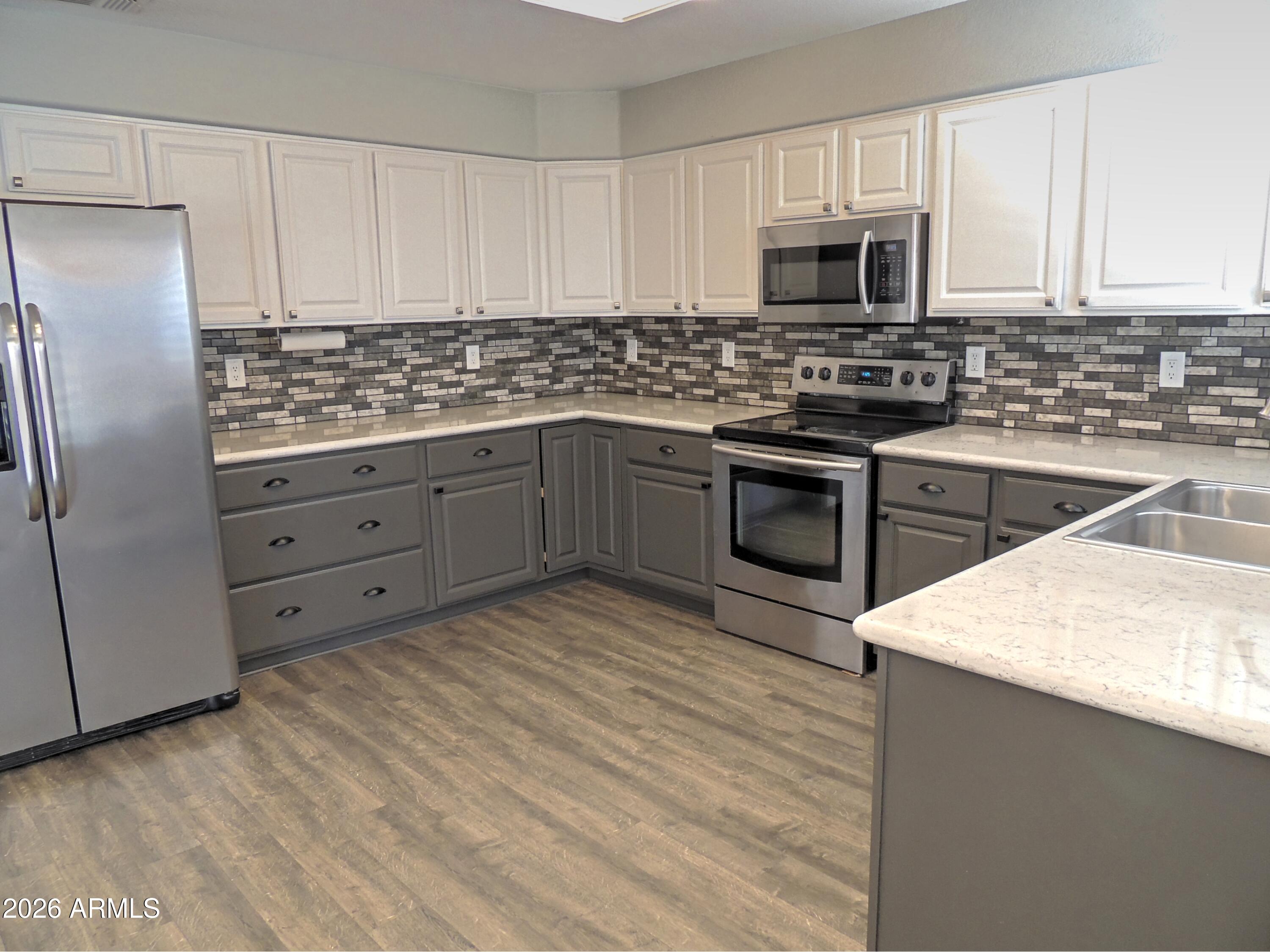 4409 East Dry Creek Road Phoenix, AZ 85044 - Photo 7 of 34 a kitchen with stainless steel appliances granite countertop a stove a sink and a refrigerator