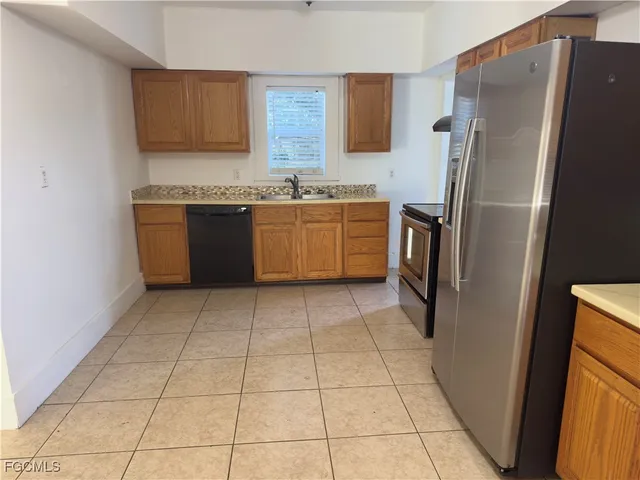 a kitchen with a refrigerator sink and cabinets