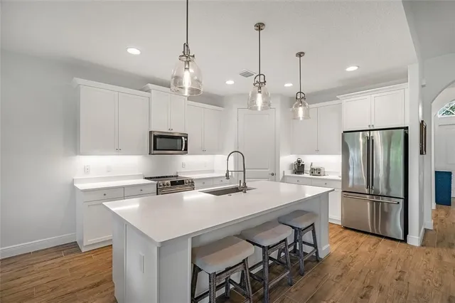 a kitchen with refrigerator cabinets and wooden floor