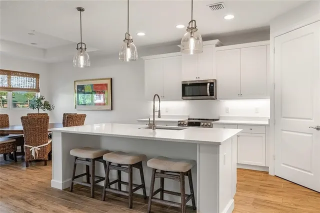 a kitchen with a dining table chairs and microwave