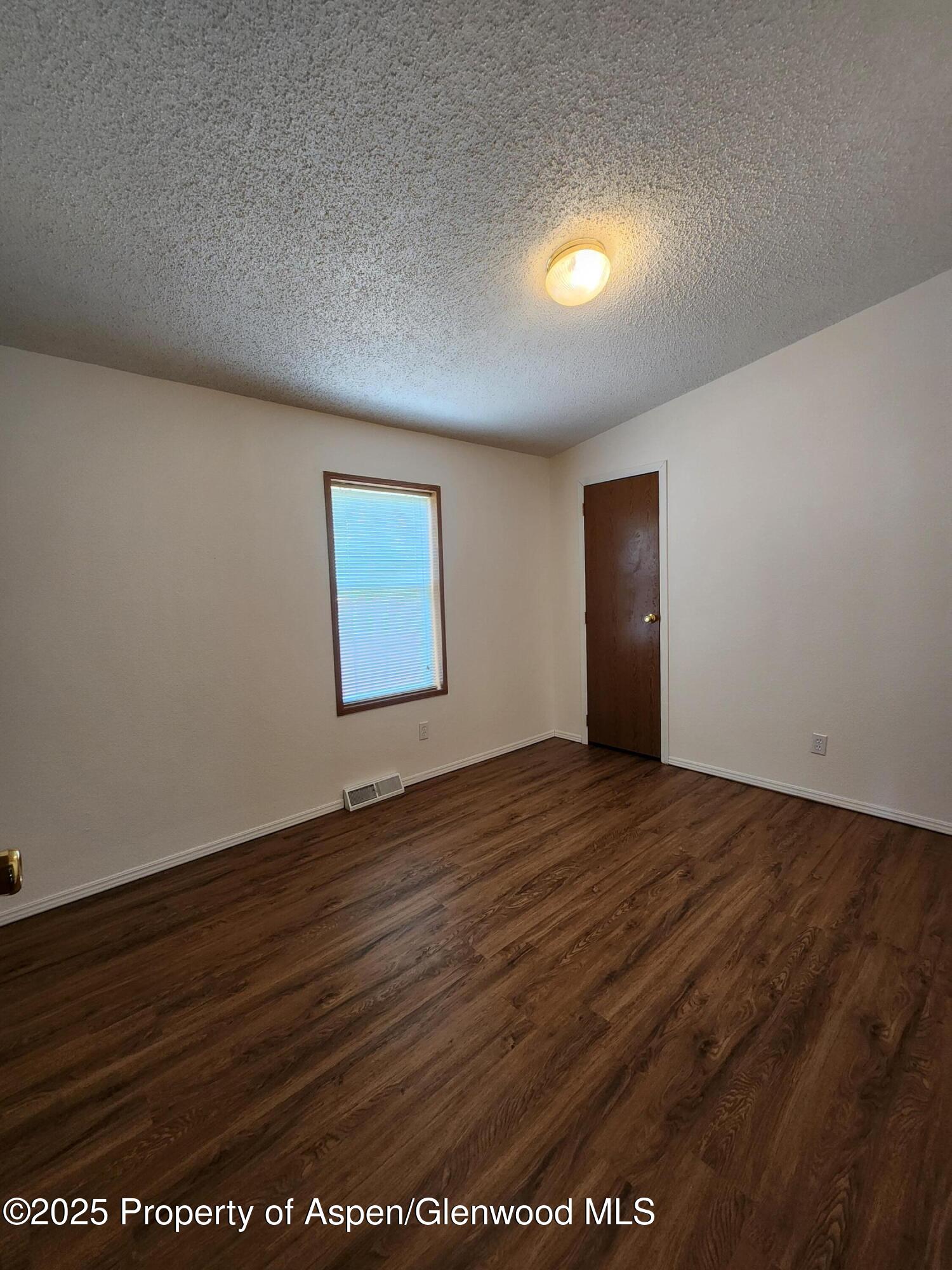 262 East Tamarack Circle Parachute, CO 81635 - Photo 3 of 18 an empty room with wooden floor and windows