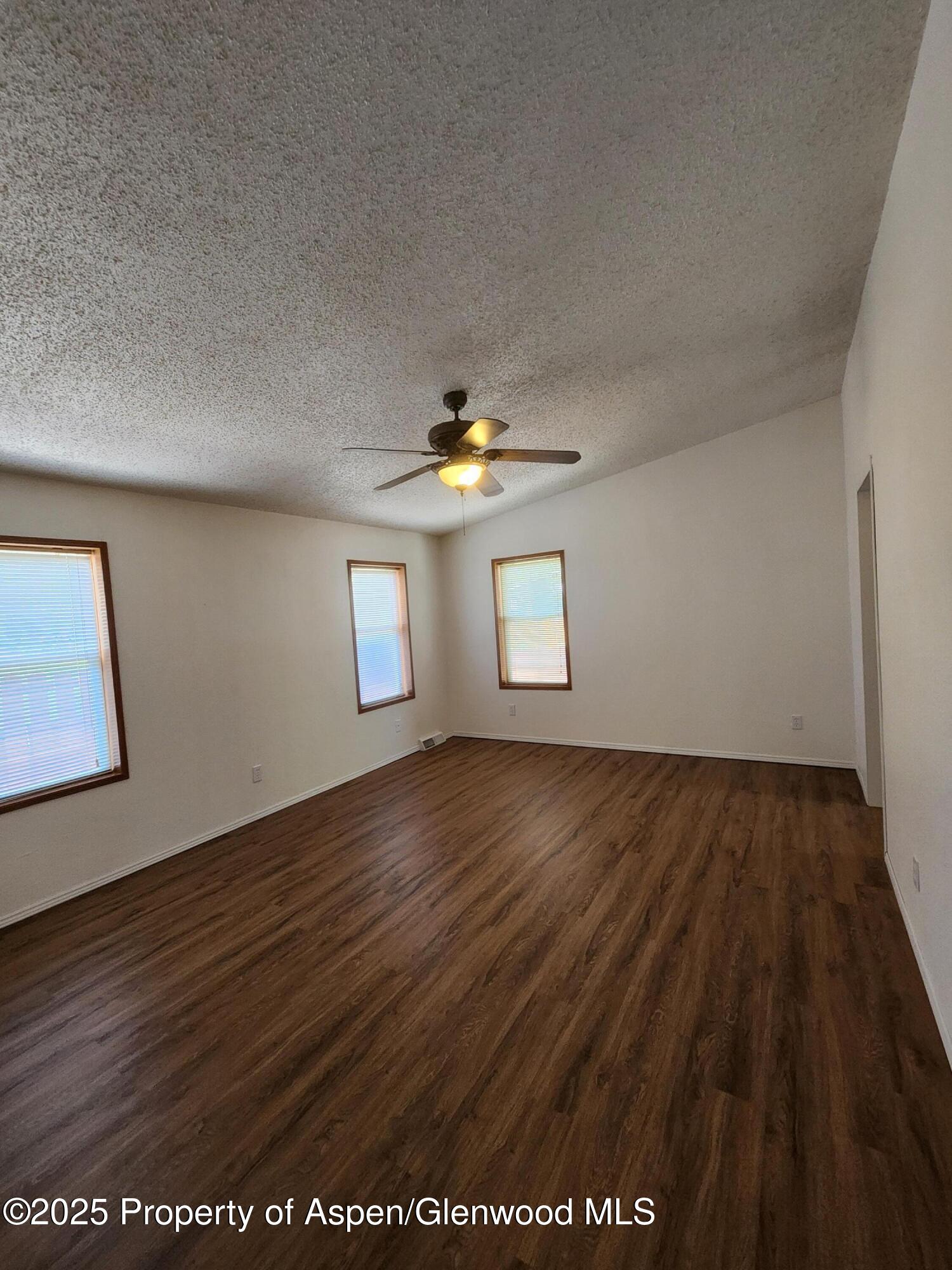 262 East Tamarack Circle Parachute, CO 81635 - Photo 4 of 18 a view of an empty room with wooden floor and a window