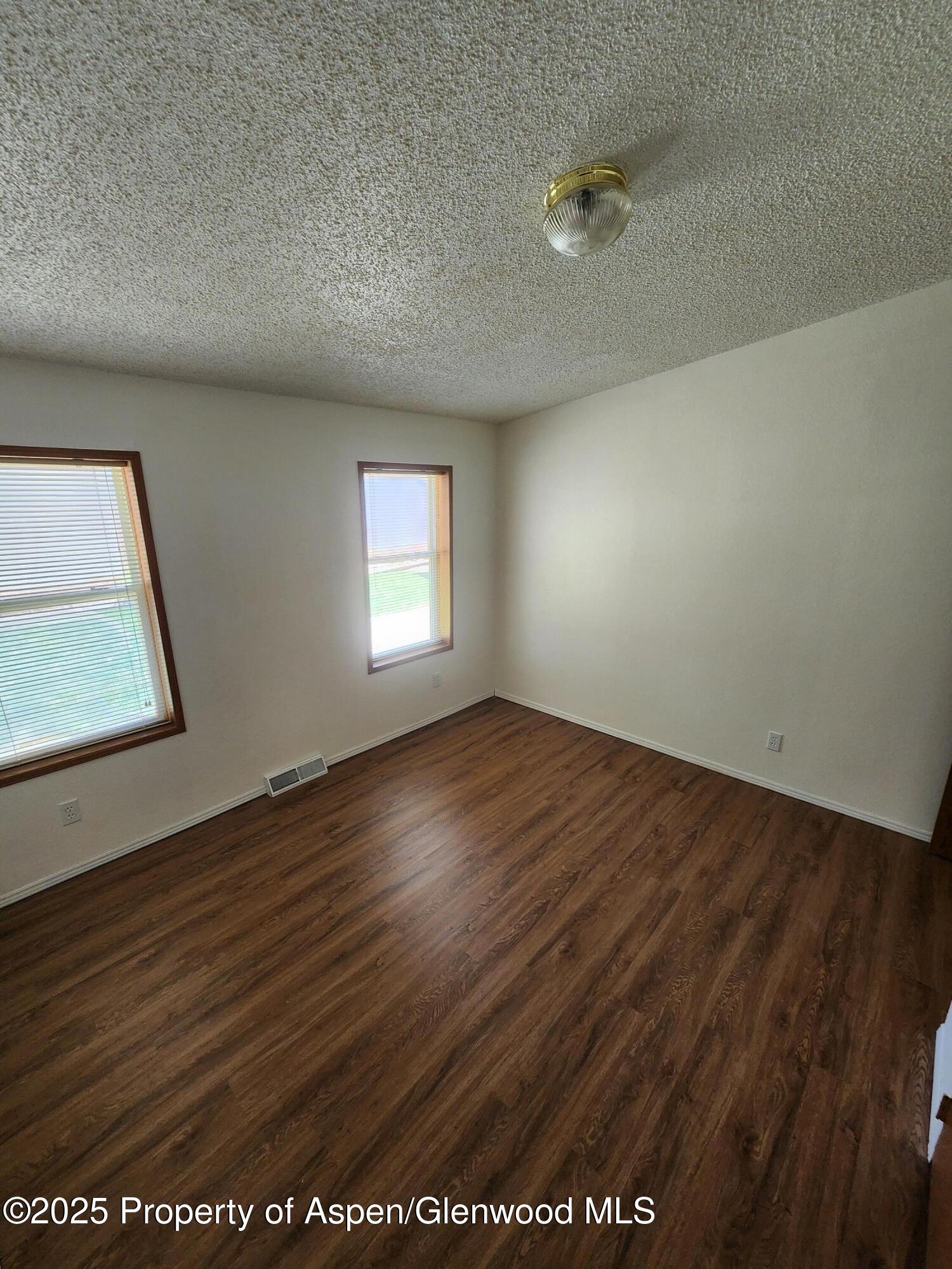 262 East Tamarack Circle Parachute, CO 81635 - Photo 8 of 18 an empty room with wooden floor and windows