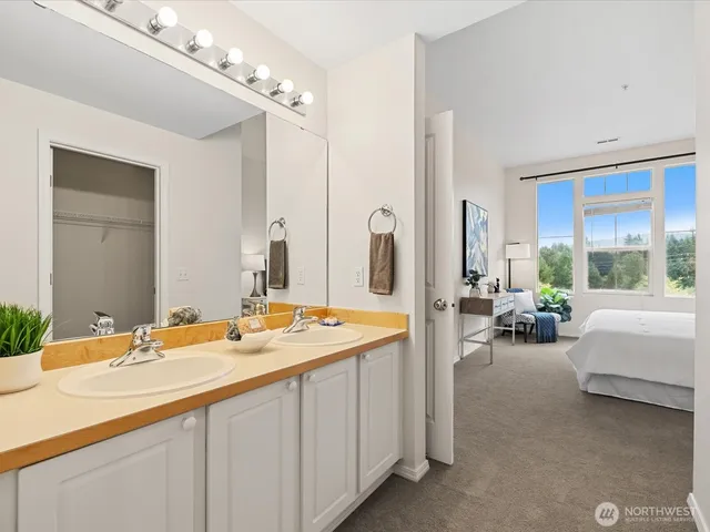 a spacious en suite bathroom with double sink and a large mirror