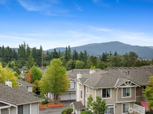 a front view of a house with a yard and mountain