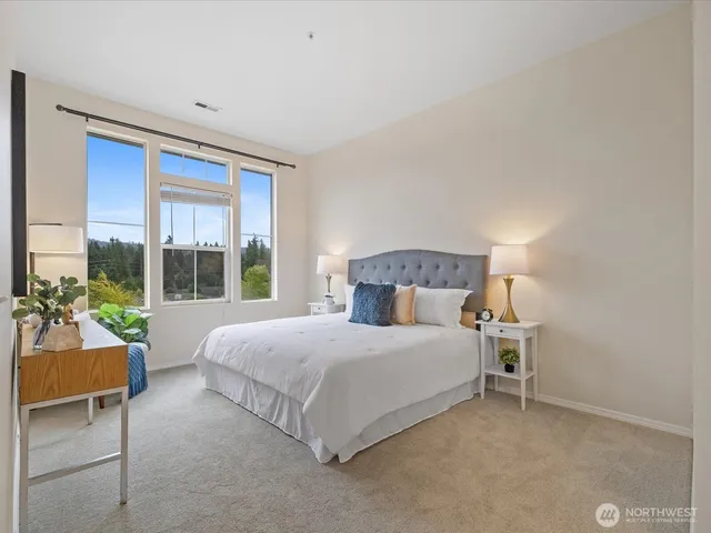 a bedroom with a bed and a large window