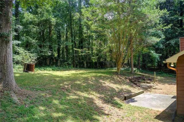 a view of a house with a yard covered by wooden fence