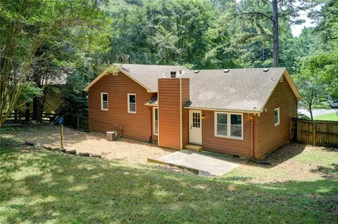 a view of an empty room with wooden floor fireplace and a window