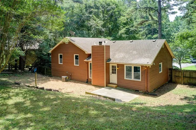 a view of an empty room with wooden floor fireplace and a window