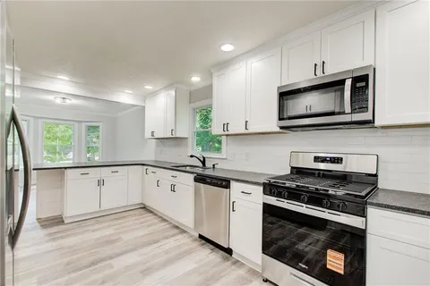 a kitchen with a sink a window and cabinets