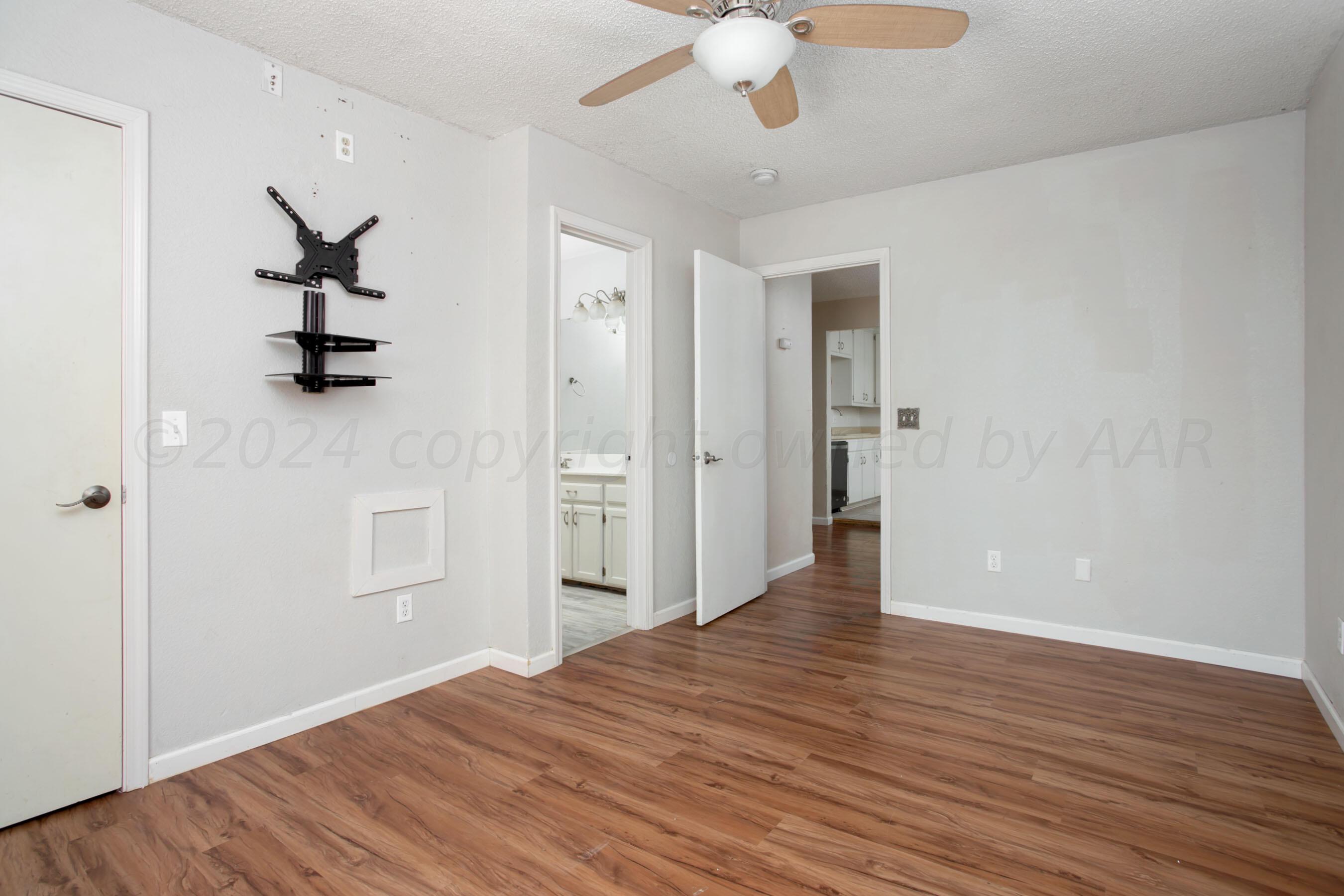 4625 South Travis Street Amarillo, TX 79110 - Photo 11 of 24 a view of an empty room with wooden floor