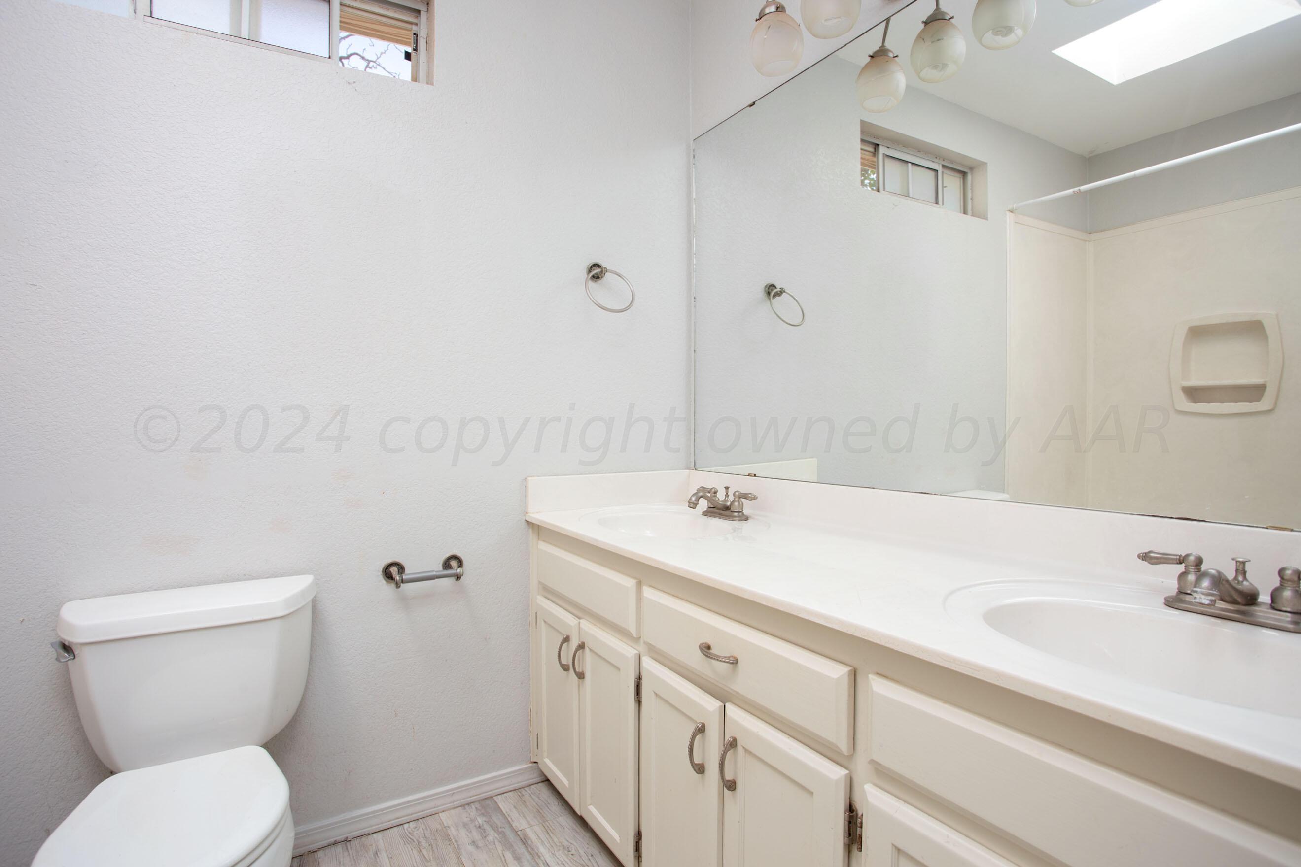 4625 South Travis Street Amarillo, TX 79110 - Photo 13 of 24 a bathroom with a granite countertop sink mirror and toilet